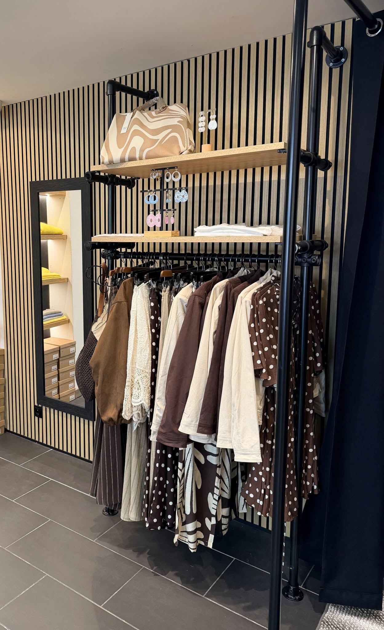 Intérieur de la boutique Maison 26, portants et coin café